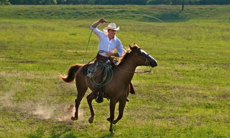 Drew Waters riding a horse with lasso