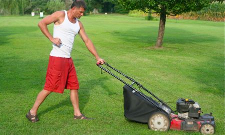 man pull starts a mower