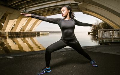 woman stretching under bridge