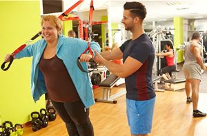 woman doing TRX with trainer